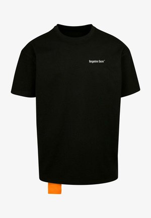 Czarna bawełniana koszulka z okrągłym dekoltem, z białym napisem "zapomniane twarze" na klatce piersiowej oraz pomarańczową metką przy dolnym brzegu.