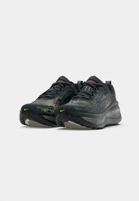 Paar schwarzer und grauer Nike ZoomX-Laufschuhe mit schimmernden Swooshes und neongrünen Akzenten auf weißem Hintergrund.