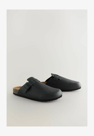 Czarne syntetyczne klapki z okrągłym noskiem, regulowanym paskiem z klamrą, korkową wkładką i teksturowaną podeszwą zapewniającą przyczepność.