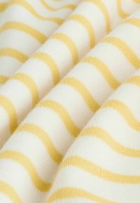 Bavlnená látka so zvlnenými pruhmi v jemnej žltej a bielej farbe. Textúra je hladká s ľahkým, útulným vzhľadom.