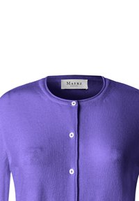 Lilla cardigan med knapper og rund halsudskæring samt et mærke "Maerz Muenchen" indeni kraven.