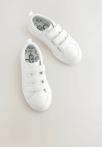 Weiße Turnschuhe mit drei Klettverschlüssen, runder Zehenpartie, glattem synthetischem Obermaterial, Gummisohle und gemusterter schwarz-weißer Innensohle.