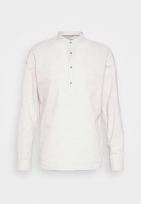 Camicia a maniche lunghe di colore chiaro in lino, con colletto alla cinese, pattina con cinque bottoni e una texture sottile.