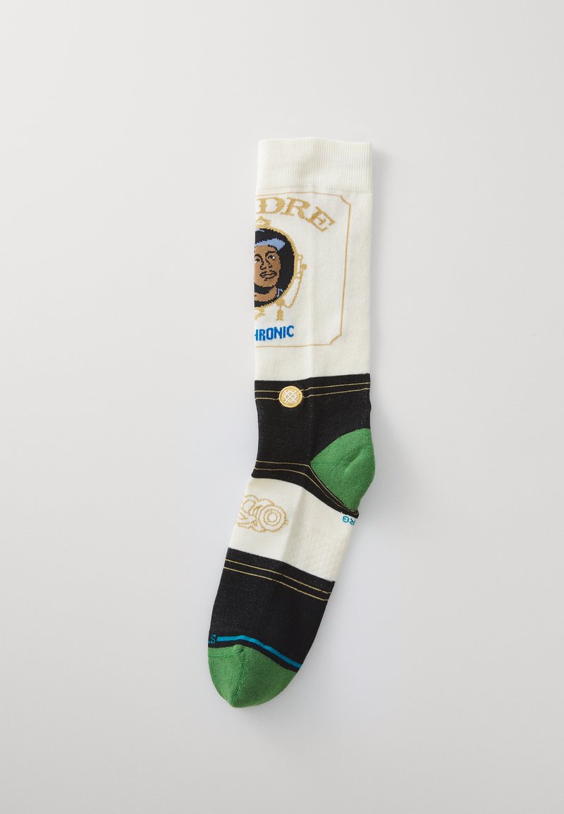 Knee-high sock made of cotton blend; cream, black, and green colors; features graphics, text, and a pattern resembling a character's portrait.