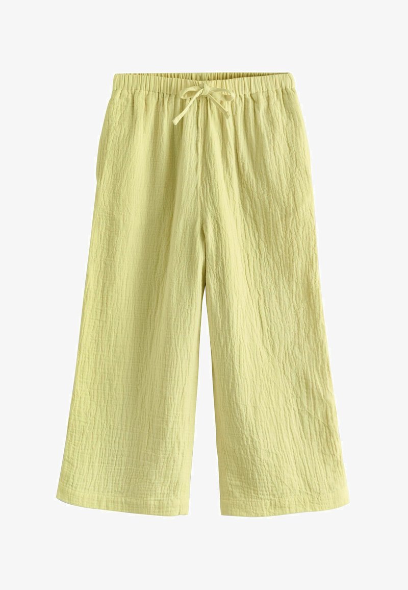 Pantalon en tissu texturé jaune pâle à jambes larges, avec une taille élastique et un cordon de serrage noué à l'avant.