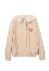 Beżowa kurtka z kołnierzem z sztucznego futra, ściągaczem na dole i dwoma bocznymi kieszeniami. Na lewej piersi naszywka z misiem, miękka w dotyku.