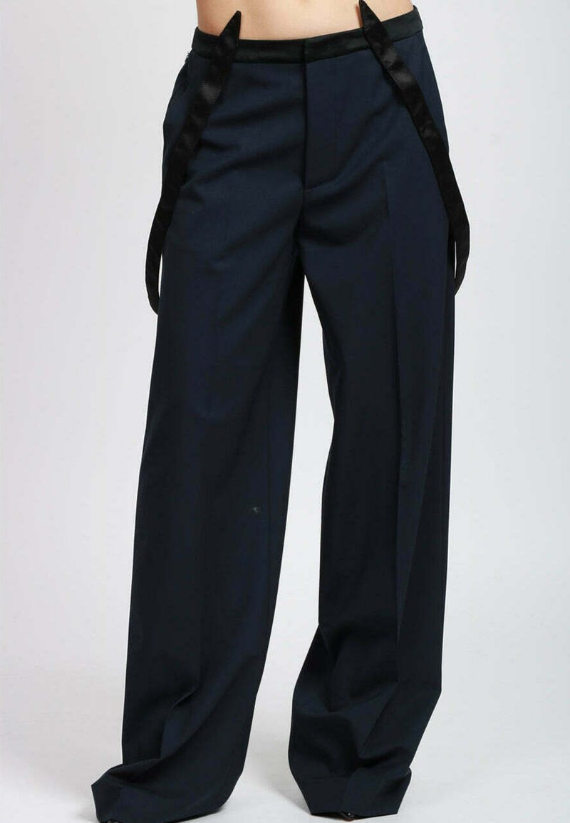Pantaloni a gamba larga in tessuto blu scuro, caratterizzati da una texture liscia, dettagli in raso sulla cintura e nastri laterali, con un taglio sartoriale.
