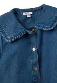 Camicia con colletto in denim blu scuro con dettagli al colletto arricciato e bottoni in oro. Presenta una texture morbida e un design classico da camicia.
