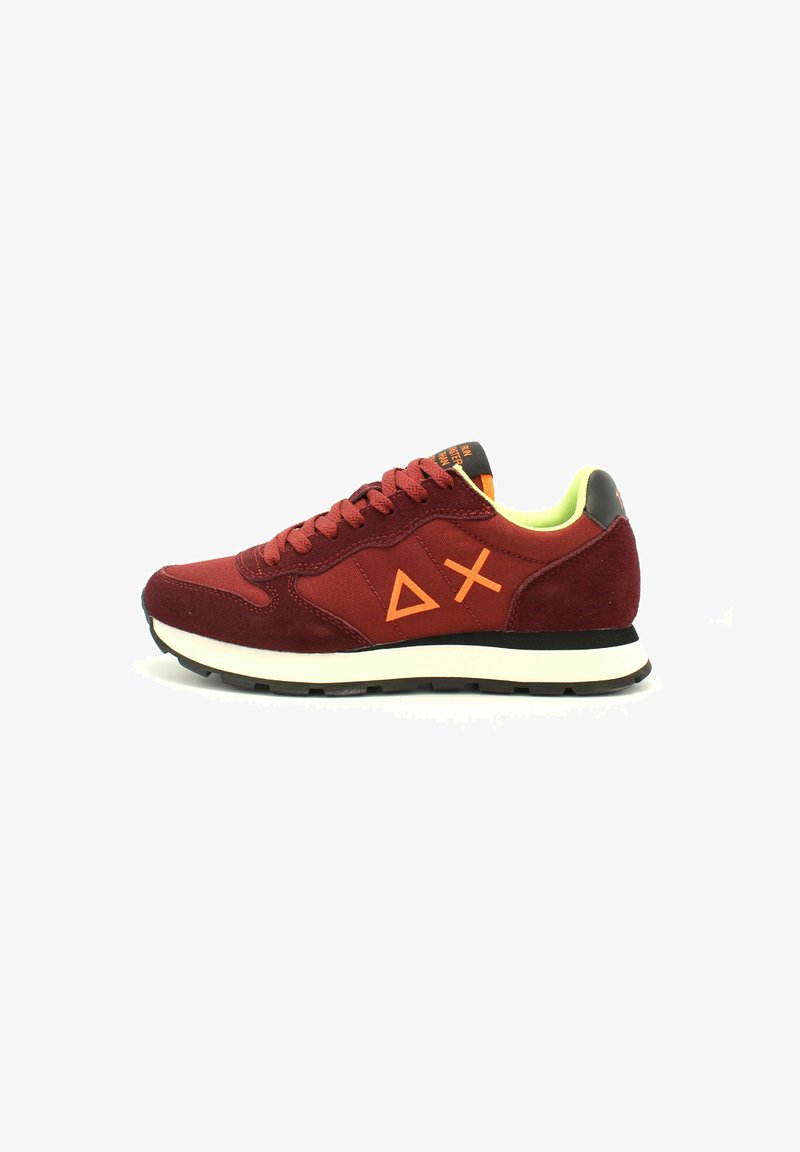 Sneaker in suede rosso con dettagli arancioni sul logo, accentuazione nera sul tallone e interno verde neon; presenta lacci tradizionali e suola bianca.