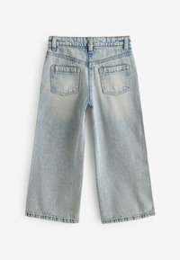 Jeans o szerokich nogawkach w jasnoniebieskim kolorze, z dwiema tylnymi kieszeniami, postrzępionymi brzegami i marszczoną talią dla większego komfortu.