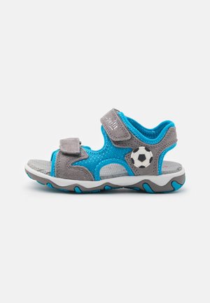 Blue and gray sandal with Velcro straps, textured upper, soccer ball graphic, and a flexible sole featuring blue accents.