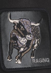 Crni zakrpa s izvezenim dizajnom bika u nijansama smeđe i sive, sa detaljnim rogovima i riječju "RAGING" u srebrnoj boji.