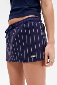 Námornícke pruhované šortky s bielymi vertikálnymi pruhmi, elastickým pásom, nastaviteľnou šnúrkou a malým vyšitým logom na okraji.