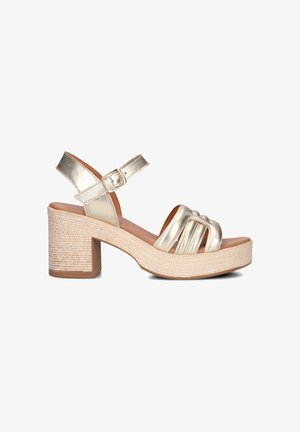 Gouden metallic platform sandalen met een geweven jute-achtige hak, voorzien van een verstelbare enkelband en een open teen ontwerp met overkrissende banden.