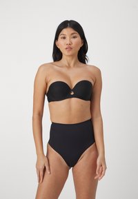 Čierna bikiny podprsenka bez ramienok s tvarovanými košíčkami a detailom v tvare kľúča, v kombinácii s čiernymi bikiny nohavičkami s vysokým pásom. Hladká tkanina bez vzorov.