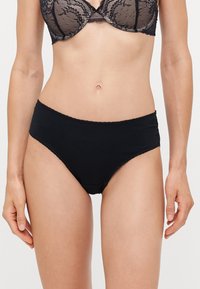 Zwarte high-waisted slipjes van gladde stof met kantafwerking langs de tailleband, met een volledige dekking en naadloze randen.