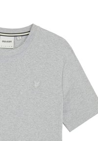 Grå bomulds t-shirt med rund halsudskæring og korte ærmer. Har et lysegrønt broderet logo på venstre bryst. Blød tekstur, afslappet design.