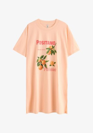 Oversized T-shirt i ferskenfarve med grafik af appelsinfrugt og grønne blade, tekst "Positano," "Refrescante y delicioso" og "Paloma" på forsiden.
