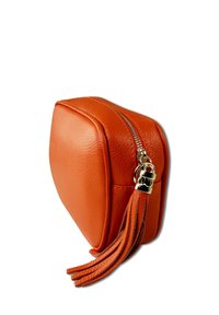 Orange Lederbeutel in quadratischer Form, mit einem Reißverschlussverschluss und einem goldenen Quastenakzent. Die Textur ist gepunktet.