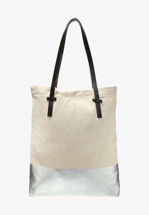 Beige Leinwand-Tragetasche mit silbernem Bodenpaneel und schwarzen Leder-Schulterriemen auf weißem Hintergrund.