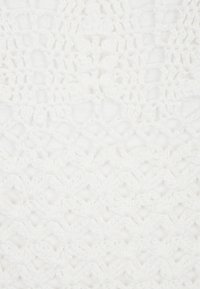 Tessuto bianco all'uncinetto con un motivo strutturato che presenta punti aperti e chiusi, creando un contrasto visivo all'interno di un design uniforme.