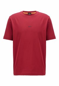 Červené bavlněné tričko s kulatým výstřihem, krátkými rukávy a jemným černým logem na hrudi. Hladká textura, uvolněný střih.