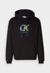 Fekete kapucnis pulóver, elöl kenguruzsebbel, húzózsinórral ellátott kapucnival, valamint egy színes "OK" logóval, alatta pedig a "Calvin Klein" felirattal.