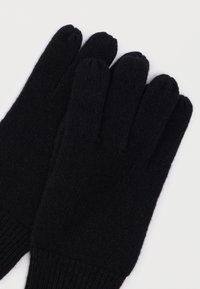 Μαύρα πλεκτά γάντια με ριμπ μανσέτα και ομαλή υφή, με πέντε ξεχωριστά τμήματα για τα δάχτυλα για ευελιξία και ζεστασιά.