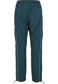 Pantalones de chándal en color azul verdoso con cinturilla ajustable, puños elásticos y ribetes laterales blancos. Tejido suave con un detalle de bolsillo trasero.
