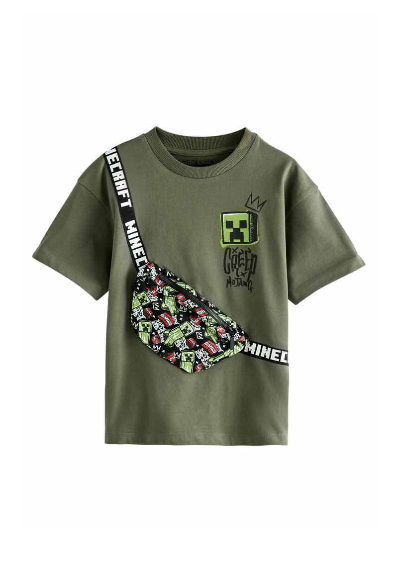 Olivegrünes Baumwoll-T-Shirt mit einem Minecraft Creeper- Grafik, kombiniert mit einer gemusterten schwarzen Gürteltasche, die verschiedene Spielcharaktere zeigt.