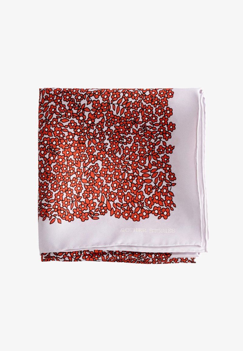 Écharpe rose pâle pliée avec un motif floral dense rouge et noir couvrant la majeure partie de sa surface.