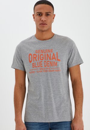 Siva pamučna majica kratkih rukava s jarkim narančastim natpisom: "ISTINSKI ORIGINAL PLAVI DENIM" i dodatnim detaljima brendiranja.