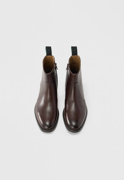 Braune Leder-Stiefeletten mit glatter Textur, abgerundeter Spitze und Reißverschluss an der Seite. Verfügen über eine kontrastierende grüne Zuglasche hinten.