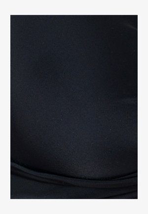 Gros plan sur un tissu noir lisse avec une texture diagonale subtile et une couture pliée près du bord inférieur.