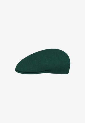 Cappello piatto in lana verde scuro con visiera curva e corona liscia e arrotondata su uno sfondo bianco.