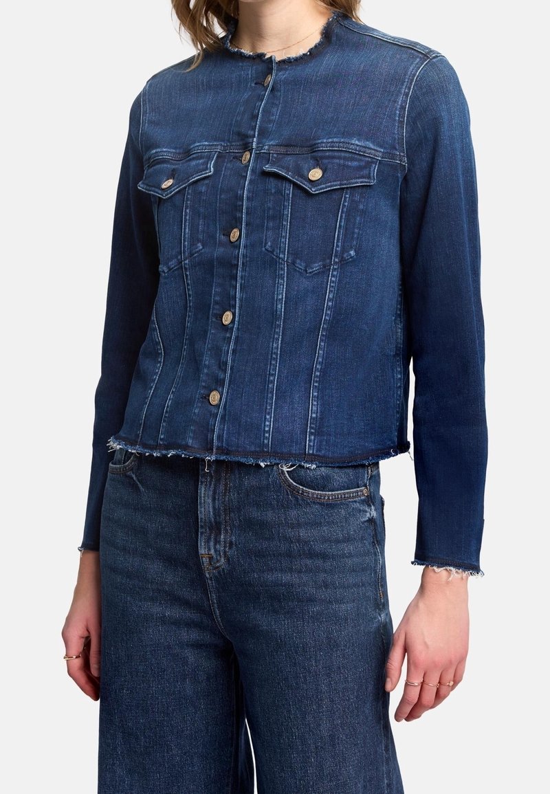 Tummansinisestä denim-takista, jossa on lyhennetty muotoilu. Ominaisuuksiin kuuluvat kaksi rintataskua, nappisulku ja repaleiset reunat hihoissa ja alaosassa.