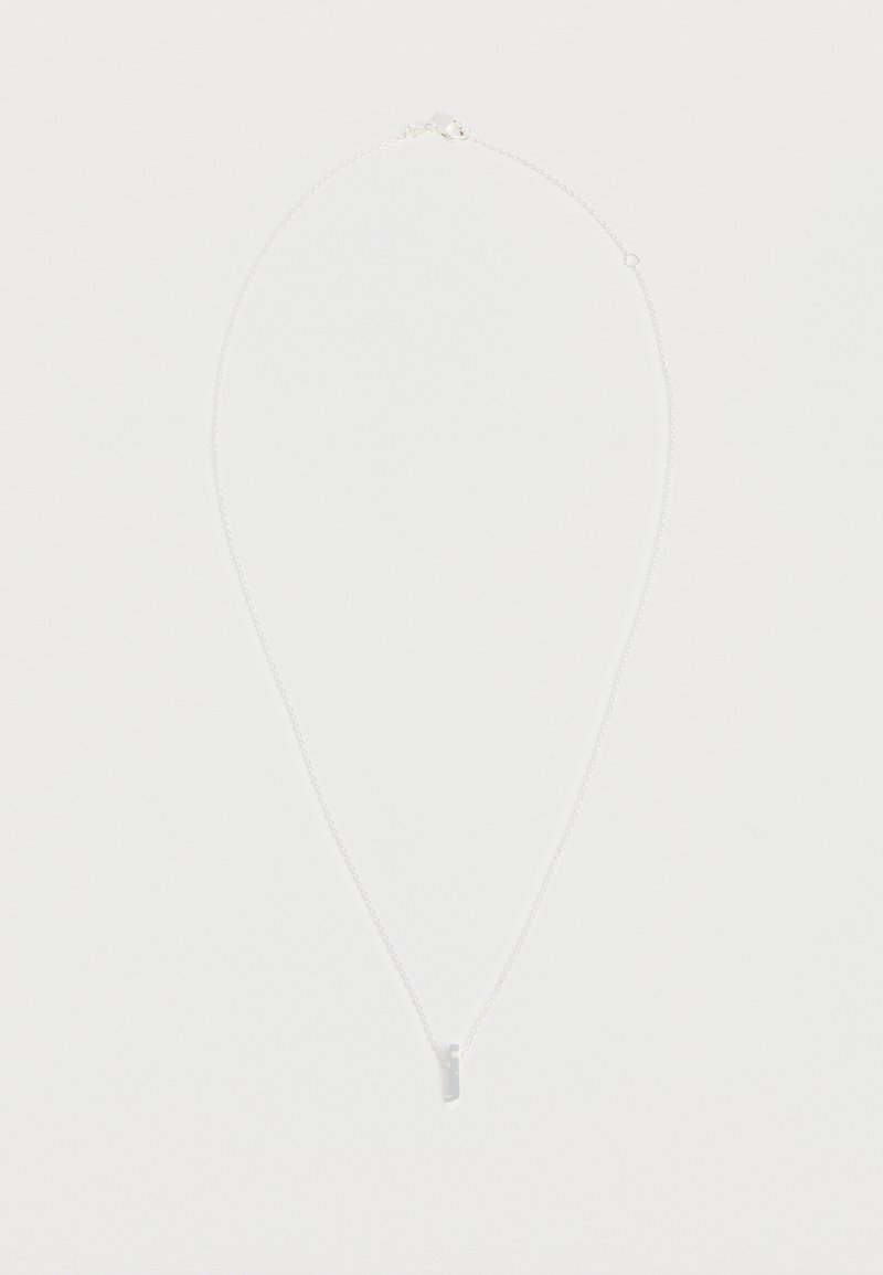 Collier fin en chaîne argentée avec un petit pendentif barre verticale sur fond blanc uni.