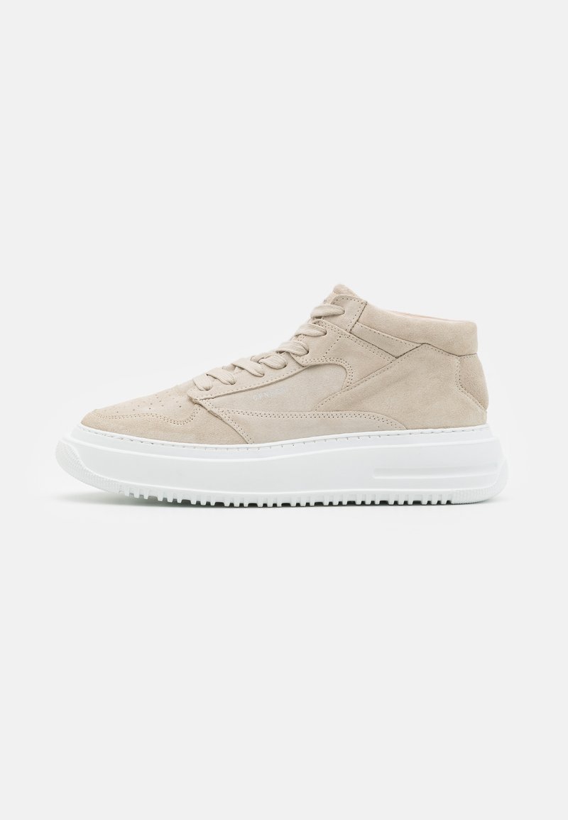 Baskets mid-top en daim beige avec semelle épaisse en caoutchouc blanc, devant à lacets et détails de panneaux cousus.