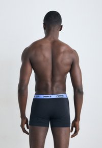 Čierne boxerky so svetlomodrým logom Nike na elastickom páse, priliehavý strih, hladká textúra a krátky strih nohavíc.