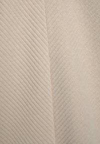 Tessuto beige chiaro a onde lucide con una trama a coste diagonali, che mette in evidenza filamenti morbidi e sottili e una leggera lucentezza.