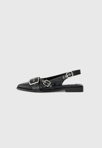 Black leather slingback shoe with a pointed toe, two silver buckles, and a low block heel. Features a textured upper and open back.