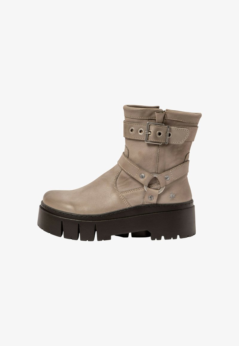 Botín de cuero beige hasta el tobillo con plataforma plana, detalle de hebilla y cremallera lateral expuesta. Presenta acentos y costuras en plata.