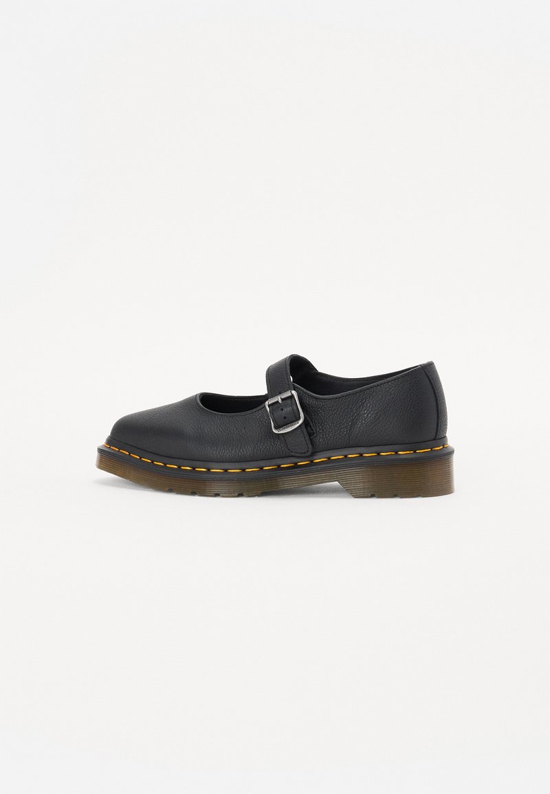 Czarne skórzane buty Mary Jane z zaokrąglonym noskiem, regulowanym zapięciem, żółtym przeszyciem i masywną brązową gumową podeszwą.