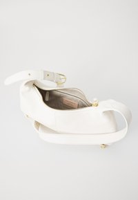 Sac à épaule en cuir blanc avec quincaillerie dorée, surface texturée, fermeture à glissière et une seule sangle réglable. Intérieur doublé.