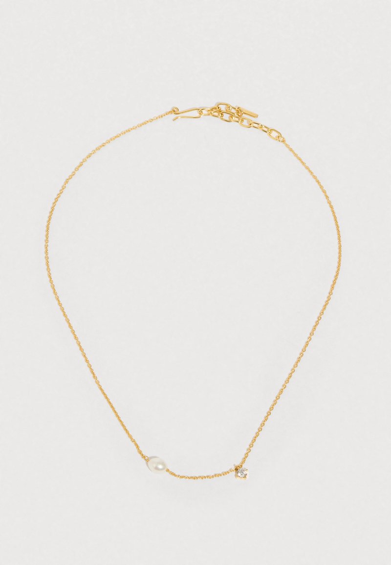 Colar com corrente dourada, apresentando uma pequena pérola e um realce de pedra preciosa transparente, com uma textura delicada e design leve.