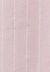 Rosa Stoff mit vertikalen weißen Streifen, der eine strukturierte Webart für ein weiches Finish aufweist. Die Streifen sind gleichmäßig verteilt und erzeugen ein unaufdringliches Muster.