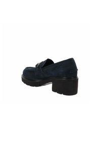 Scarpa moccasin in suede blu navy con tacco spesso nero, caratterizzata da una cintura sul collo del piede e dettagli di cucitura sottili.