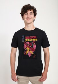 Czarny T-shirt z grafiką w stylu komiksowym przedstawiając�ą Deadpoola i Wolverinea w żywych kolorach, na tle różowego serca w kształcie tła.