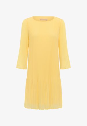 Robe jaune plissée longueur genou avec manches longues et encolure ronde, fabriquée en tissu léger.