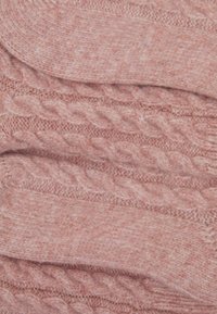 Mehka rožnata pletenina s teksturiranim vzorcem, ki vsebuje povišane pletenice in gladek zaključek. Idealno za topla oblačila ali dodatke.